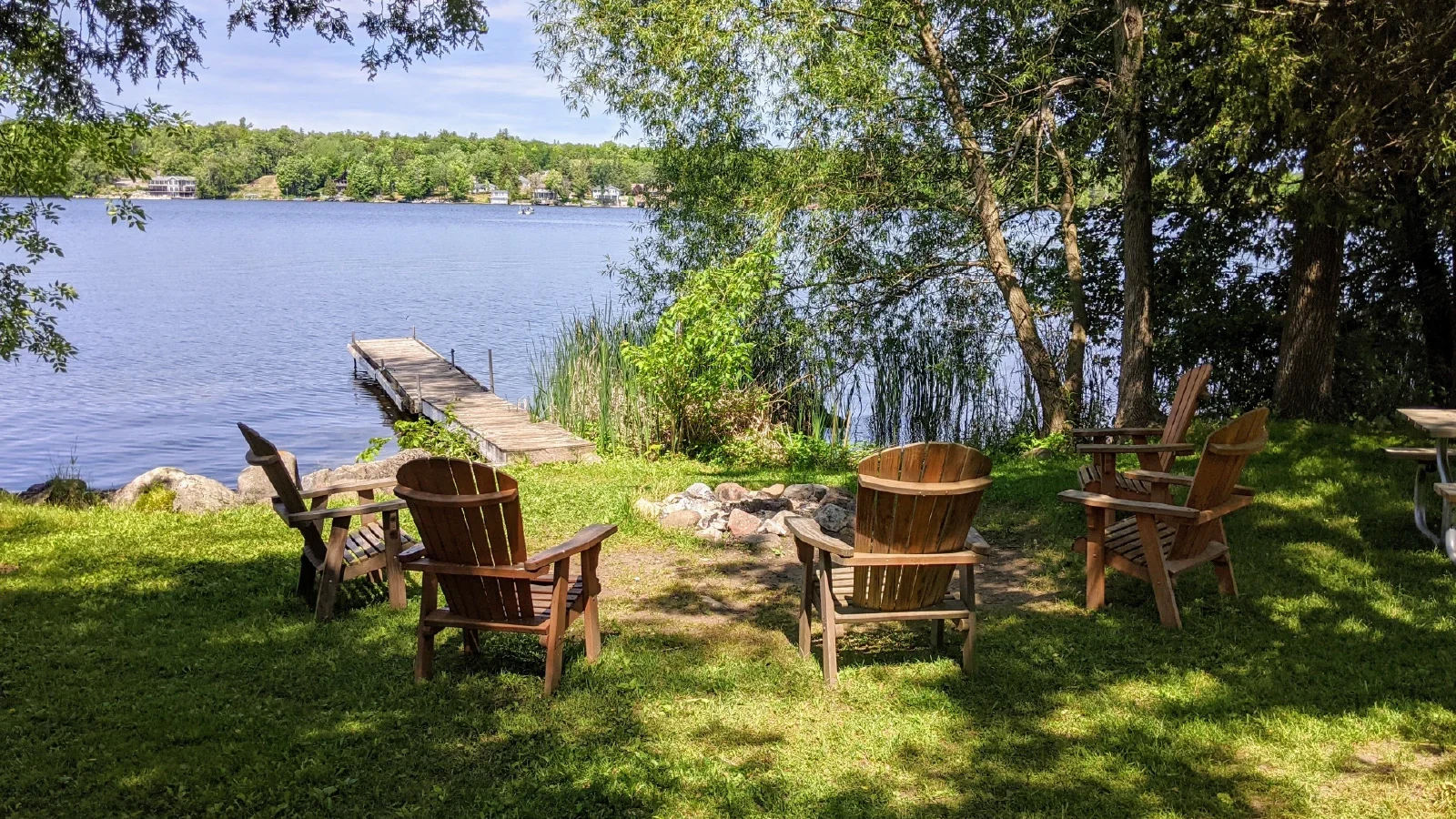 Cottage 4 waterfront fire pit and Adirondack chairs with private dock at Pigeon Lake cottages Kawartha Lakes Ontario