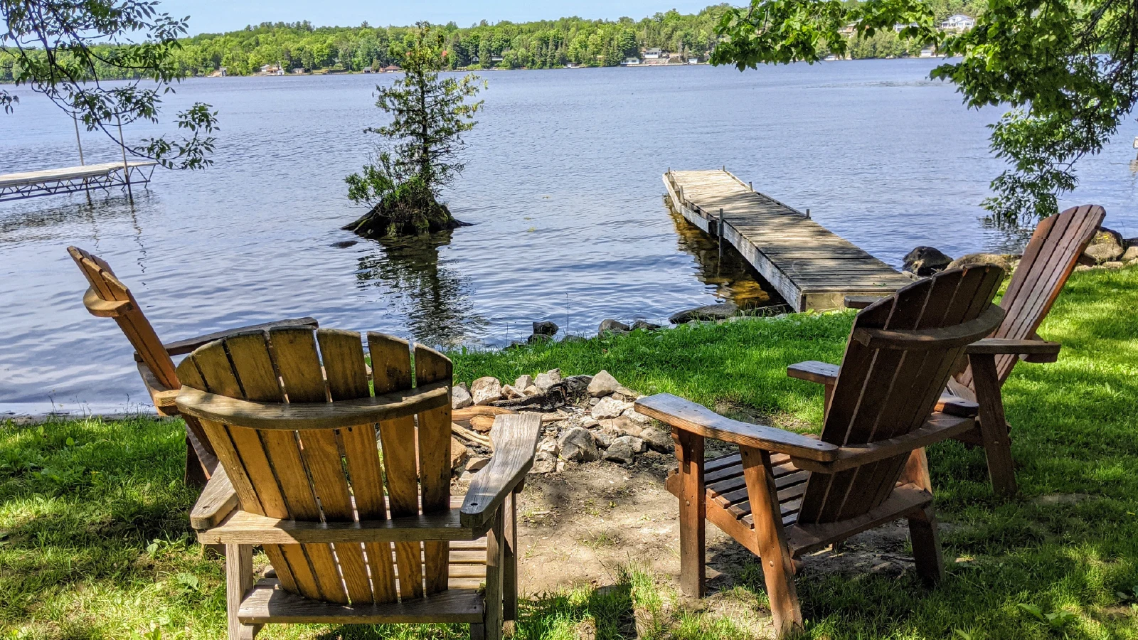 Cottage 3 waterfront fire pit with Adirondack chairs and private dock on Pigeon Lake in Kawartha Lakes Ontario