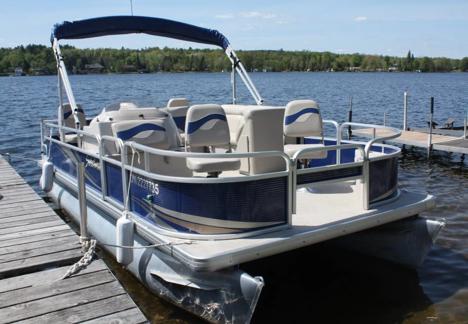 Pontoon boat docked at Pigeon Lake Resort Cottage on Pigeon Lake in Kawartha Lakes Ontario